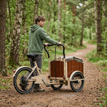 tienerjongen met bakfiets op bospad